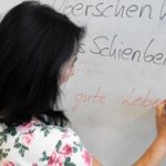 Frau schreibt auf Whiteboard