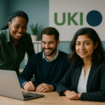 Ein KI-generiertes Bild von drei Personen. Die Frau links steht und ist leicht über den Tisch vor sich geneigt. Sie schaut den Laptop am Tisch an und lächerlt. Rechts von ihr sitzen ein Mann und eine Frau. Beide lächeln. Die Frau blickt in die Kamera. Im Hintergrund sieht man ein Plakat mit der Aufschrift "UKI".